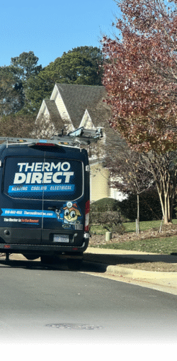 A Thermo Direct service van for heating, cooling, and electrical work is parked on a suburban street in front of a house with trees and bushes nearby.